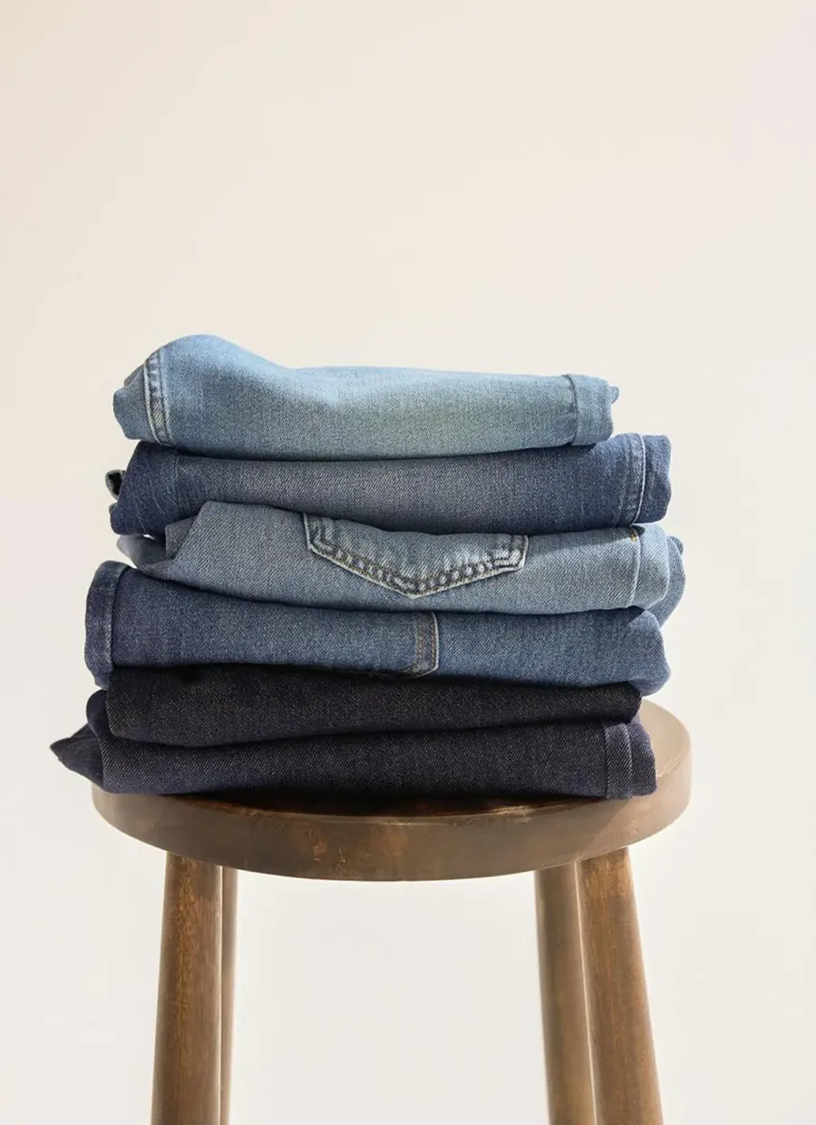 Customer photo of a stack of folded jeans on a wooden stool